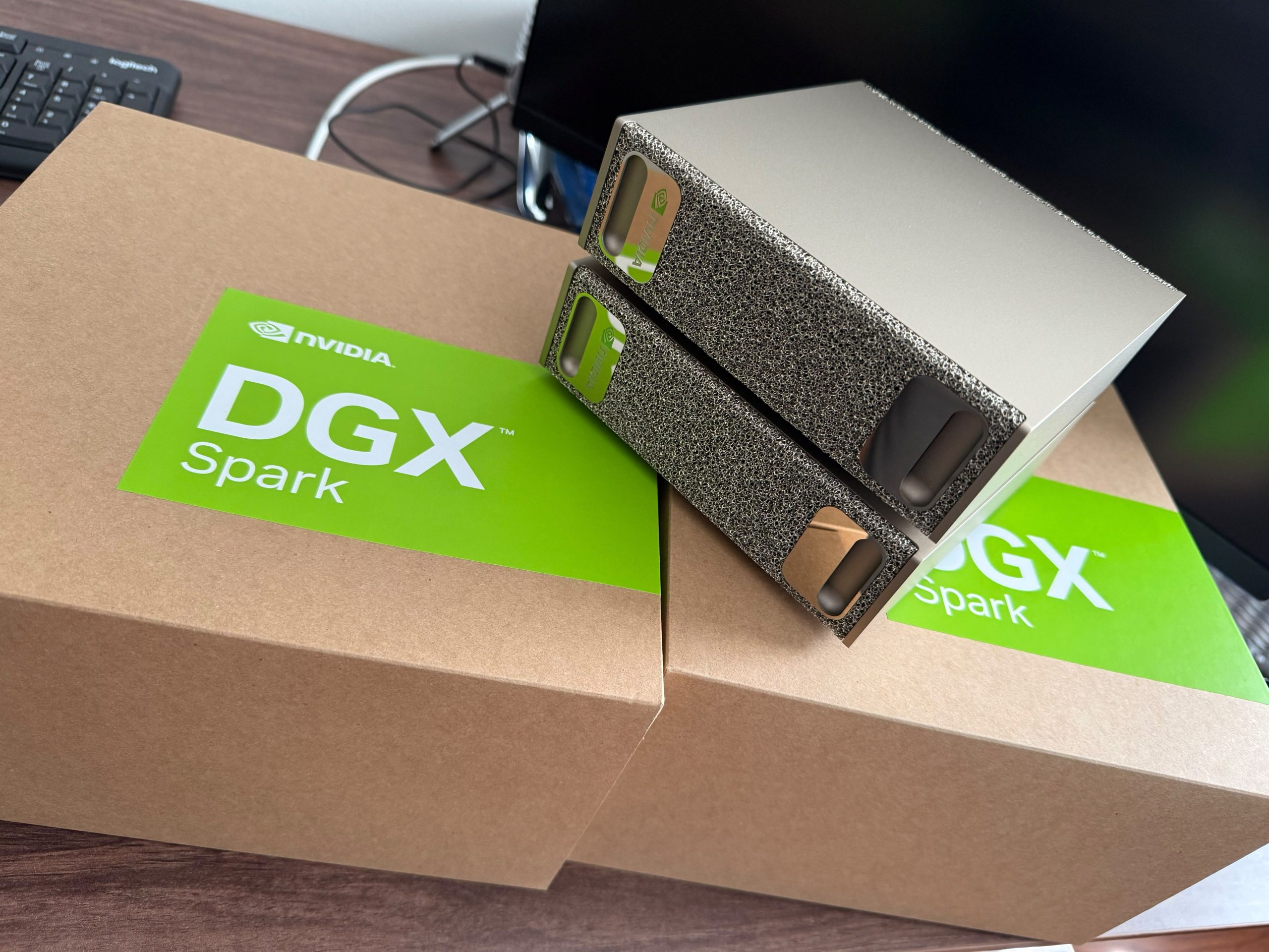 Two NVIDIA DGX Spark units resting on their shipping boxes on a desk
